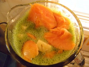 papaya and pineapple with green smoothie in blender jug