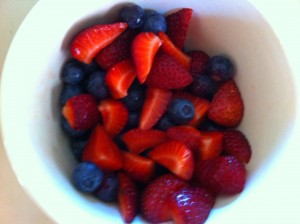bowl of strawberries quartered and blueberries