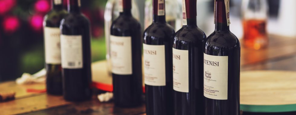benefits of red wine - line of red wine bottles