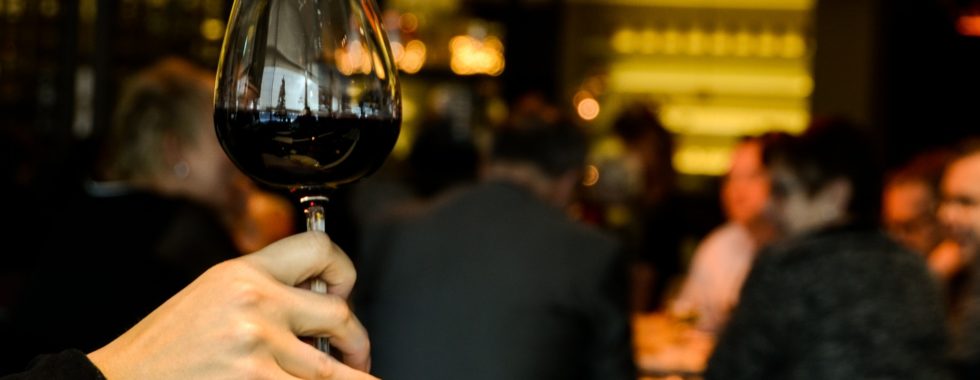 benefits of red wine - woman holding wine in a restaurant